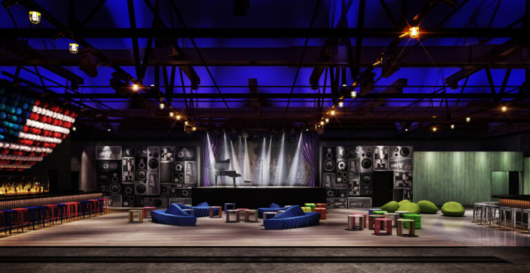 Asbury Lanes interior with a central performance stage, speaker-covered walls, colorful low lounge seating, and blue overhead lighting.