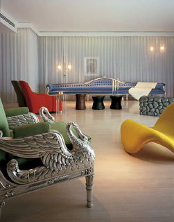 Sanderson Hotel room with an ornate silver armchair, bright yellow sculptural chaise, blue patterned daybed, and pale striped curtains.